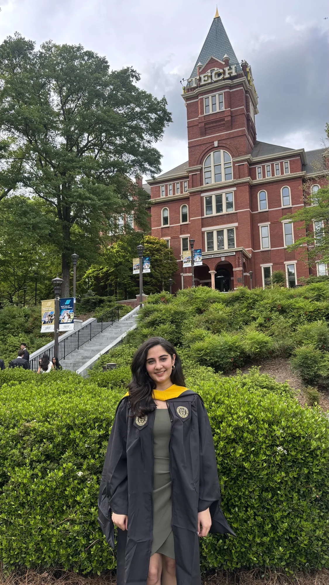Darshi in graduation regalia in front of the Georgia Tech tower
